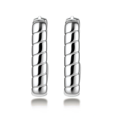 Close-up of platinum-plated sterling silver hoop earrings with horizontal textured grooves on white background.