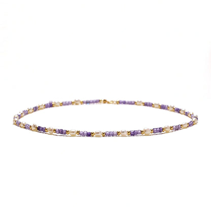 Delicate 18K gold vermeil necklace with alternating lavender zirconia beads and white freshwater pearls on cream background