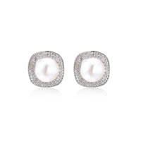 Rhodium-plated sterling silver stud earrings with round freshwater pearls surrounded by geometric crystal halos on cream background.
