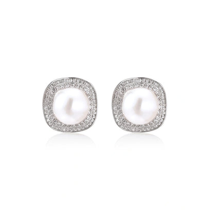Rhodium-plated sterling silver stud earrings with round freshwater pearls surrounded by geometric crystal halos on cream background.