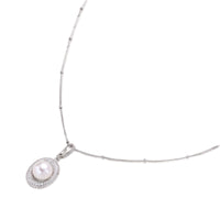 Oval sterling silver pendant with crystal halo surrounding a white freshwater pearl on delicate chain