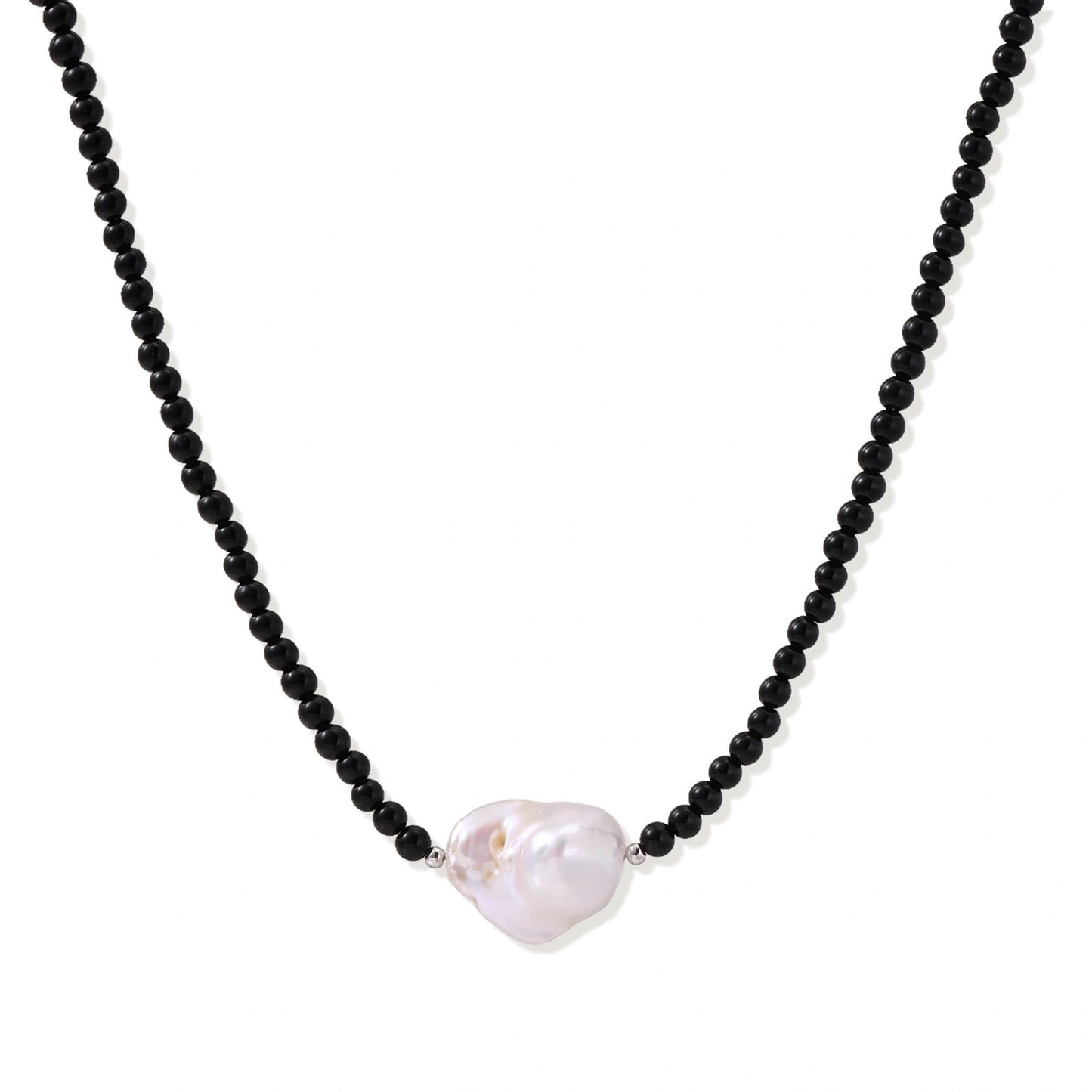 Beaded black agate necklace with iridescent baroque freshwater pearl centerpiece on cream background.