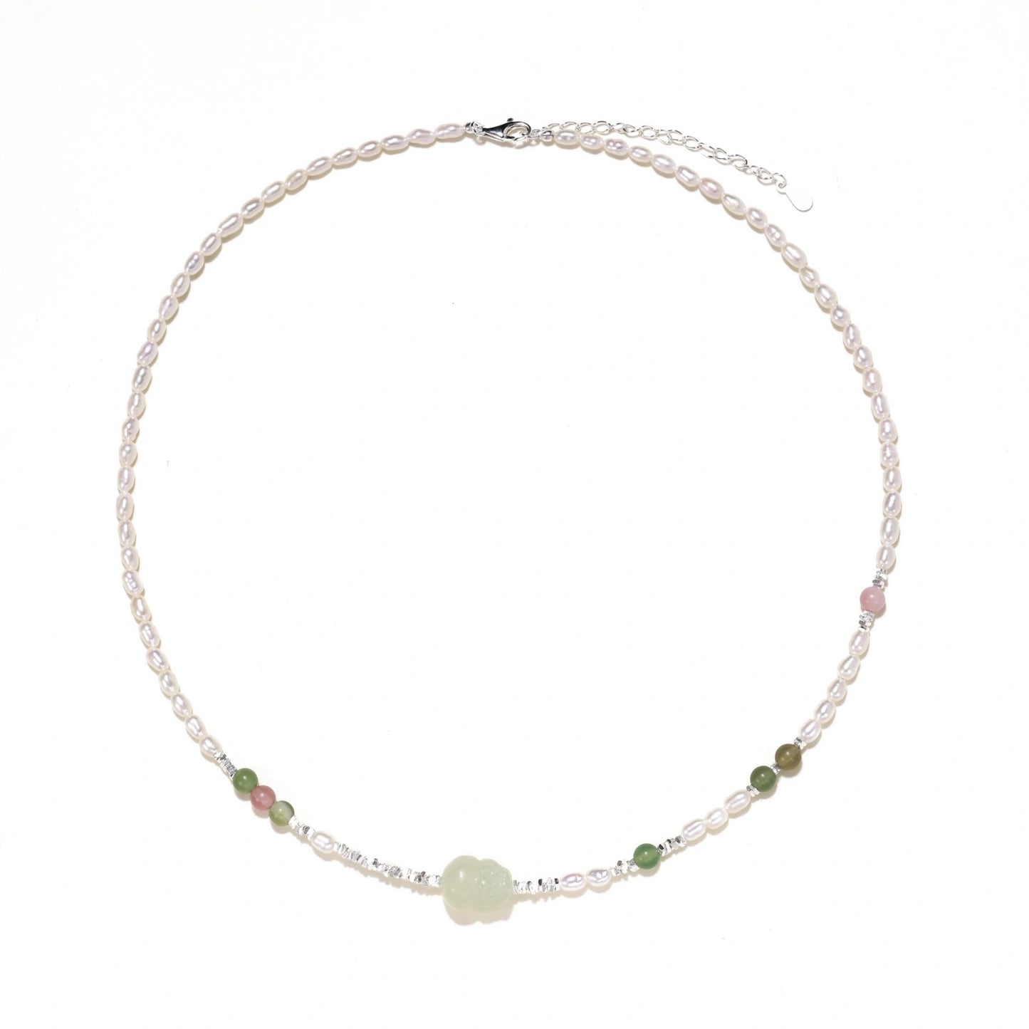 Delicate pearl necklace with pale green serpentine jade centerpiece and colorful agate beads on cream background