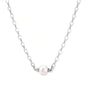 Dainty rhodium-plated silver chain necklace with centered 10mm freshwater pearl and crystal accents on cream background