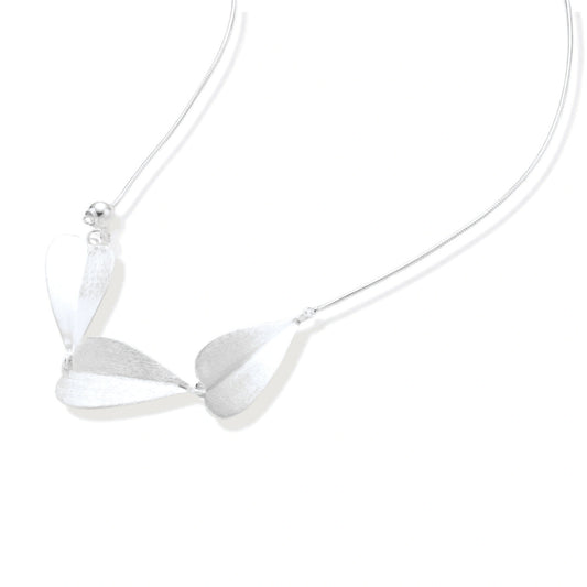 Minimalist sterling silver necklace with three brushed leaf-shaped pendants on delicate chain against white background