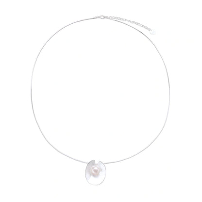 Sterling silver disc necklace with textured finish and centered freshwater pearl on delicate chain