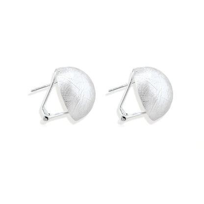 Brushed sterling silver half-dome clip-on earrings with textured surface against cream background