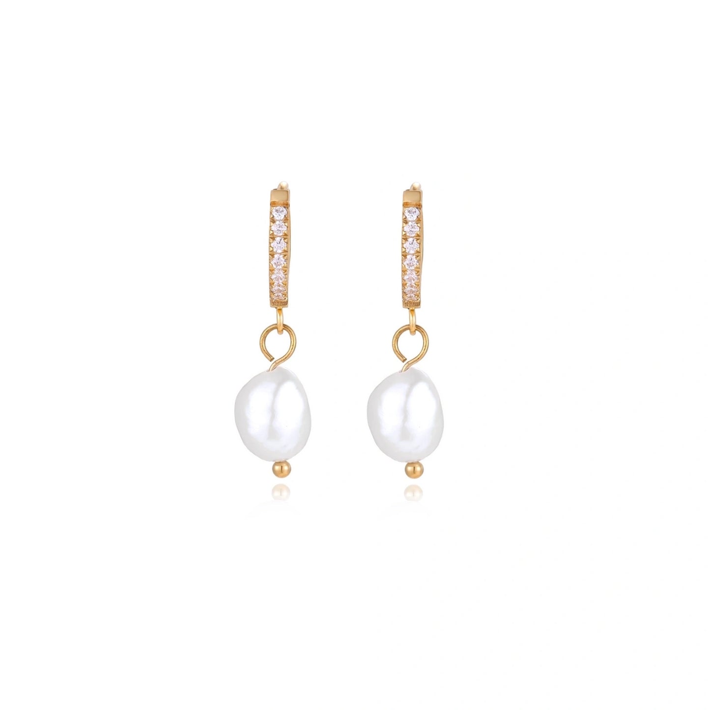 Gold huggie hoop earrings with pavé crystals and white freshwater pearl drops on cream background