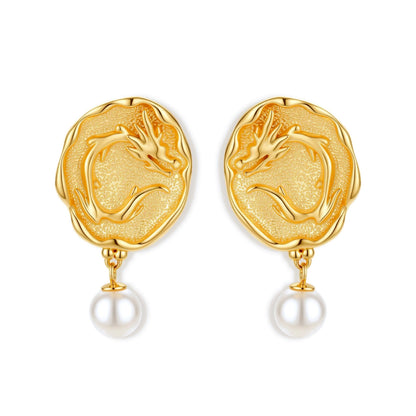 Ornate gold-plated dragon medallion earrings with white shell pearl drops on beige background, featuring detailed Chinese motifs.