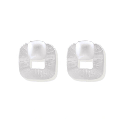 Pair of geometric sterling silver earrings with frosted square frames and glossy rounded studs on white background