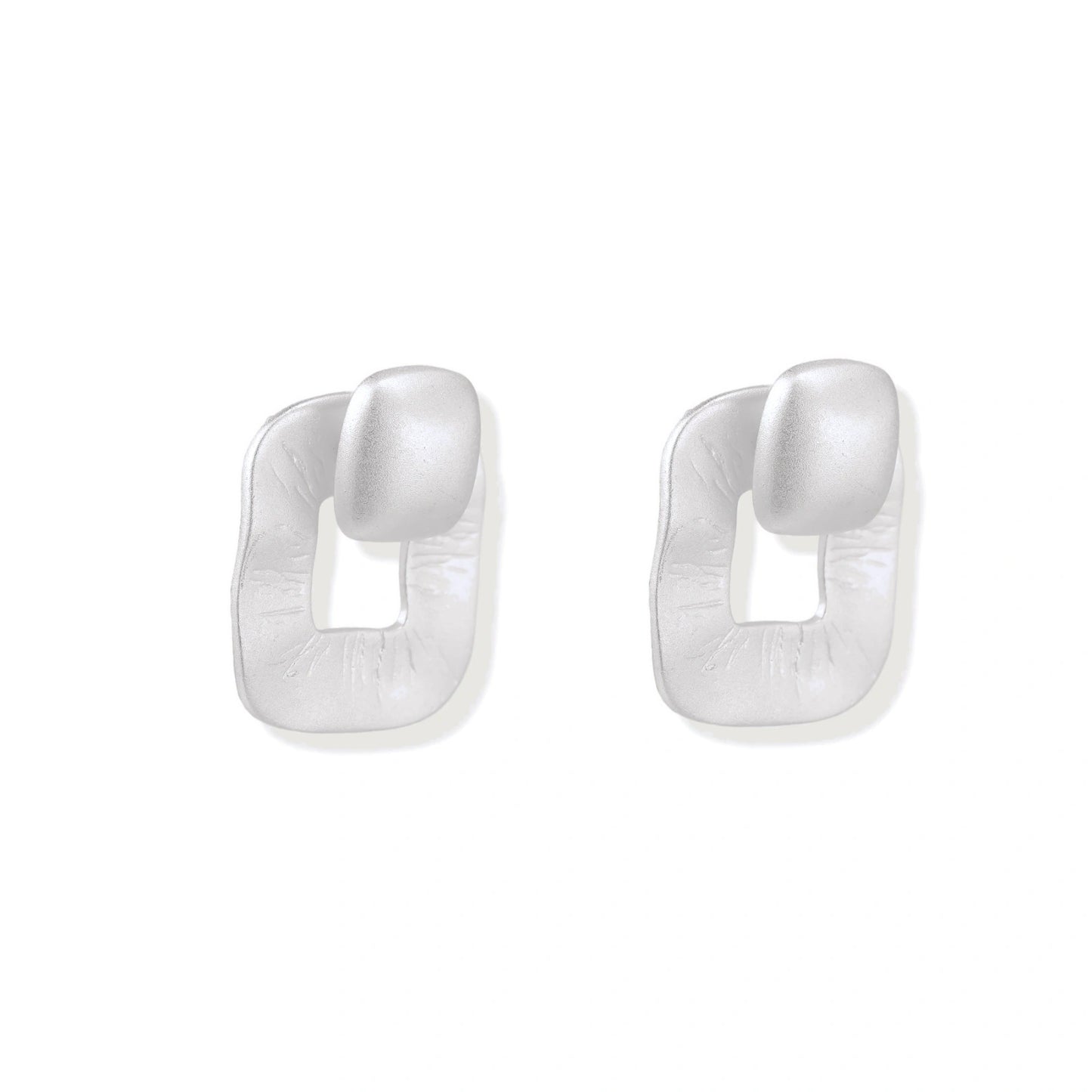 Pair of geometric sterling silver earrings with frosted square frames and glossy rounded studs on white background